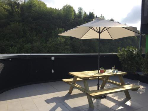 a picnic table with an umbrella on a patio at Talo Urban Rooms in Donostia-San Sebastián