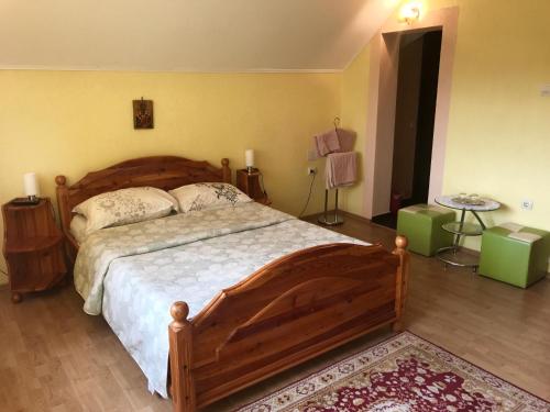 - une chambre avec un grand lit en bois dans l'établissement Vila La Izvor, à Petreşti