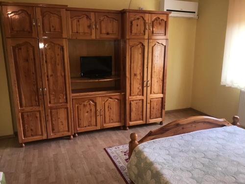 a bedroom with a tv and a large wooden cabinet at Vila La Izvor in Petreşti