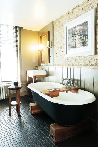 a large bath tub in a bathroom with a sink at Hotel du Vin & Bistro Cambridge in Cambridge