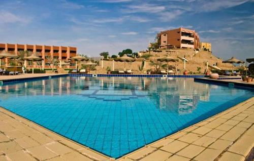 a large blue swimming pool with a building in the background at Fanar Hotel in Ain Sokhna