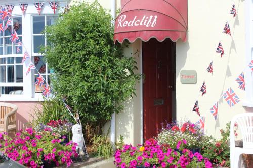 a building with a redcliffe sign and flowers in front of it at The Redcliff in Weymouth