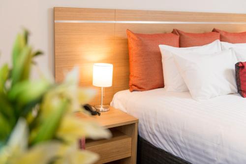 a bedroom with a bed and a lamp on a table at Adelaide Royal Coach in Adelaide