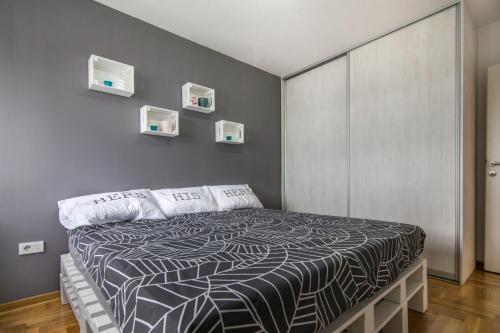 a bedroom with a bed with a black and white comforter at VortexLuxApatman in Belgrade
