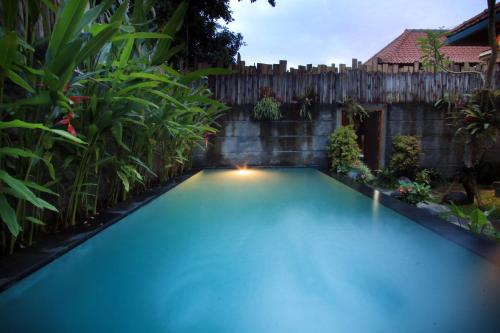 a swimming pool in a backyard with a fence at The Forest Villa Ubud in Ubud