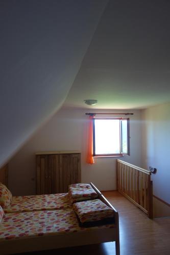 sypialnia z łóżkiem i oknem w obiekcie Apartmani Konak Kik w mieście Zaovine