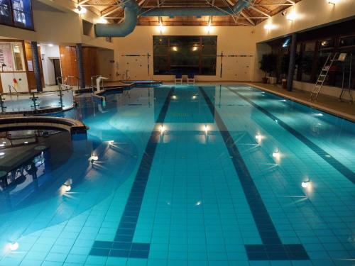 a large swimming pool with blue water in a building at Tullamore Court Hotel in Tullamore