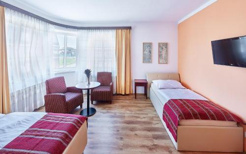 a hotel room with two beds and a tv at Penzion Karolinka in Kroměříž