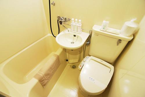 Hotel New Star Ikebukuro في طوكيو: حمام صغير مع مرحاض ومغسلة