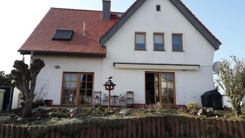 a white house with a fence in front of it at Ferienwohnung im Rhein-Main Gebiet nahe Frankfurt, Rödermark in Rödermark