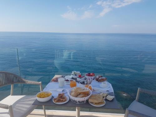 a table with food on it next to the ocean at Capo Torre Resort & SPA in Albisola Superiore