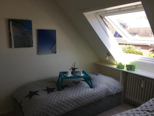 Un dormitorio con una cama con una mesa azul. en Sylter Ferienwohnungen, en Westerland