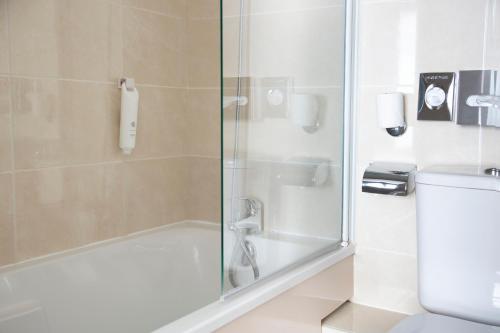 baño con ducha y puerta de cristal en Hotel Bootcamp, en Issy-les-Moulineaux