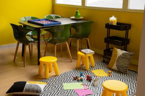 a dining room with a table and chairs and a table and stool at Hotel Bootcamp in Issy-les-Moulineaux