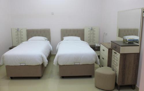 En eller flere senger på et rom på Manarat Manah Hotel Apartments