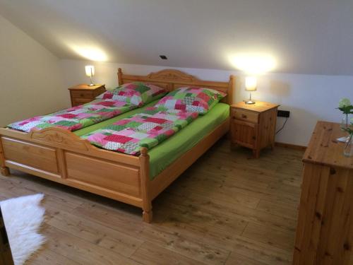 a bedroom with a wooden bed with two night stands at Ferienwohnung Niederrhein-Oase in Kevelaer