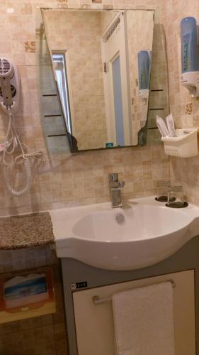 a bathroom with a sink and a mirror at Dory Inn in Nangan