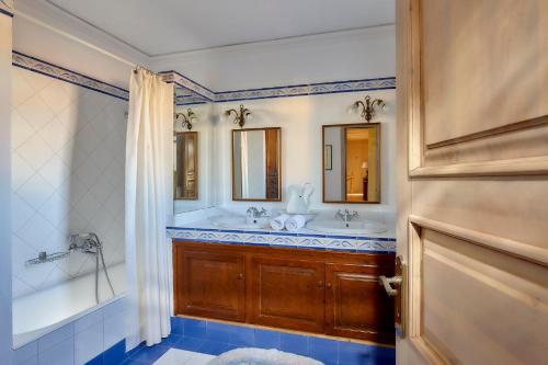 a bathroom with two sinks and a tub and a shower at Castello Villa Daphnes - Private Pool & Whirlpool in Dhafnés