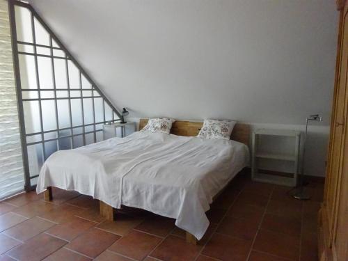 1 dormitorio con 1 cama con sábanas y almohadas blancas en Ferienwohnung Haus am Barg, en Heikendorf