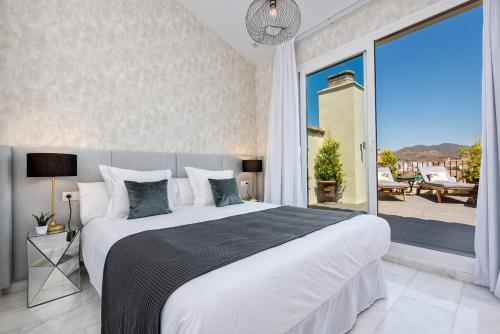 a bedroom with a large bed and a large window at iloftmalaga Deluxe Alameda Principal in Málaga