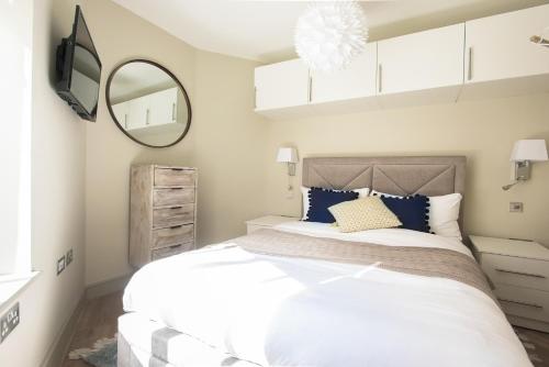 een slaapkamer met een groot bed en een spiegel bij The Mayfair Parade - Trendy 1BDR in Londen