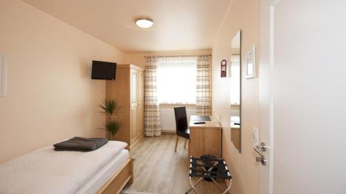 コブレンツにあるHotel-Pension Hommenのベッドルーム1室(ベッド1台、デスク、窓付)
