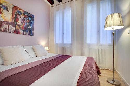 a bedroom with a large bed and a lamp at Botteri Palace Apartments in Venice