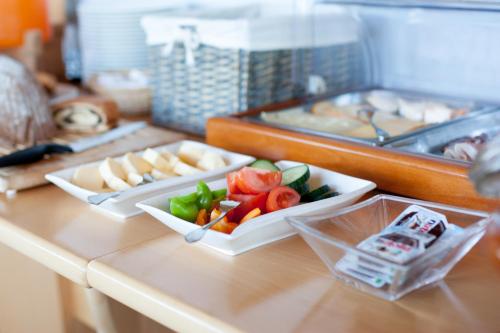 two plates of food on a counter with vegetables at Gasthof Pension Zoller in Wolfsberg