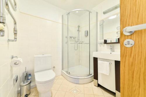 a bathroom with a shower and a toilet and a sink at Superior Hotel Vantis Riverside in Rīga