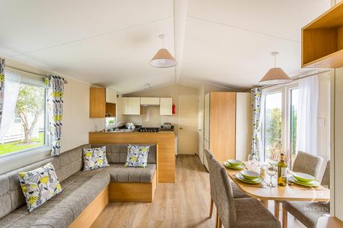 a living room and kitchen with a couch and a table at Ingoldale Holiday Park in Ingoldmells