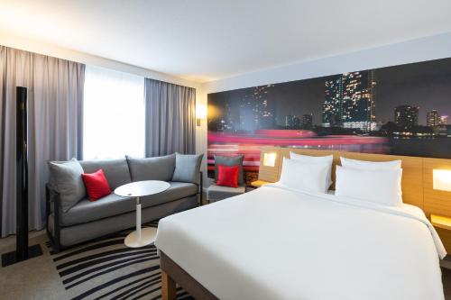 a hotel room with a bed and a couch at Novotel Bordeaux Centre Ville in Bordeaux