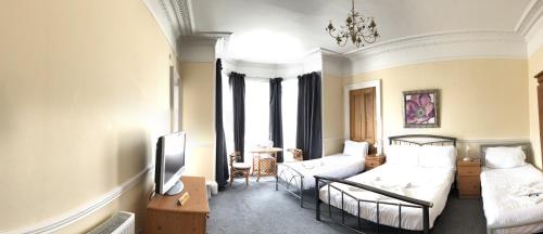 uma sala de estar com uma cama e um sofá em Cruachan Guest House em Edimburgo