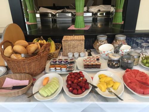 einen Tisch mit Teller mit Lebensmitteln und Schalen mit Früchten in der Unterkunft Hotel zum Grafen Hallermunt in Springe