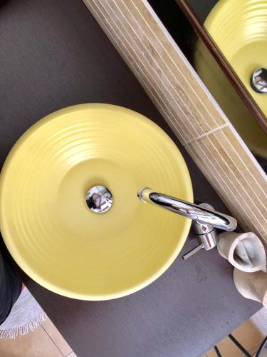 a yellow plate in a sink with a pair of scissors at Marina Di Castello in Cagliari