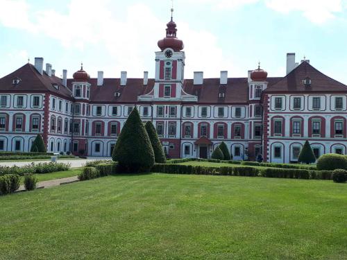 a large building with a lawn in front of it at Chalupa pod zámkem in Mnichovo Hradiště