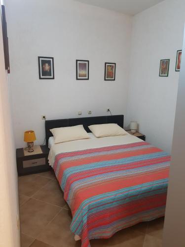 a bedroom with a bed with a colorful blanket on it at Gudelj Apartments in Perast