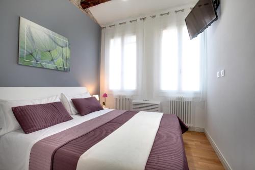 a bedroom with a large bed in a room with windows at Botteri Palace Apartments in Venice