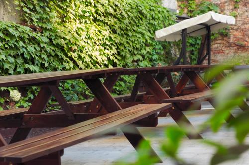 a wooden picnic table with a bench at Patio Hostel in Bratislava