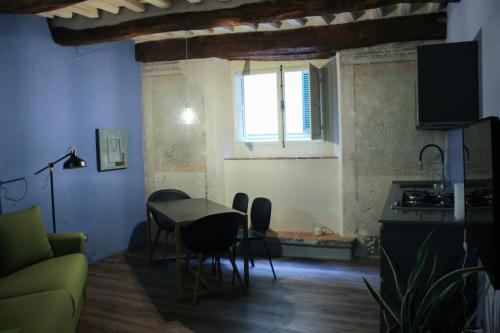 a living room with a table and chairs and a kitchen at LuccaStay 18 in Lucca
