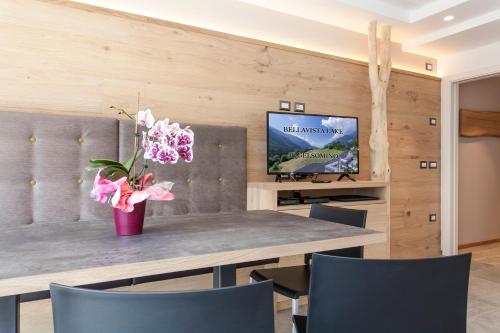 une salle à manger avec une table et un vase de fleurs dans l'établissement Bellavista - Lake, à Molveno