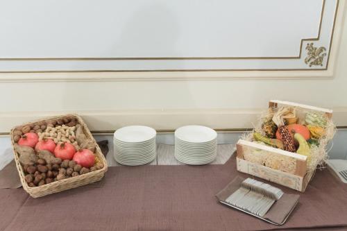 two baskets of fruits and vegetables sitting on a table at Hotel Grand'Italia in Padova