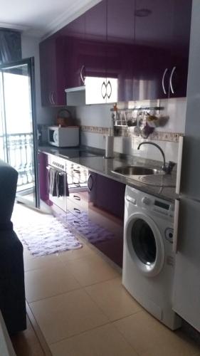 a kitchen with a sink and a washing machine at Península de la paz in Lugo