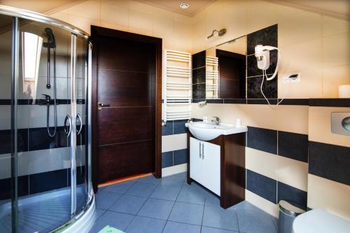 ein Bad mit einer Dusche und einem Waschbecken in der Unterkunft Hotel Platinum Hrubieszów in Hrubieszów