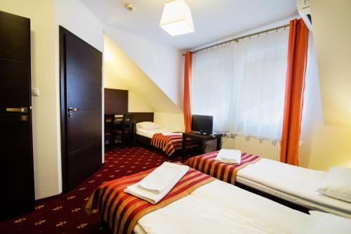 Łóżko lub łóżka w pokoju w obiekcie Hotel Jagiełło