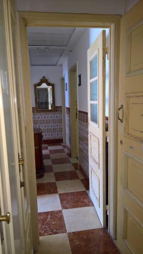 an open door to a room with a checkerboard floor at Casa Dom Manoel in Portalegre