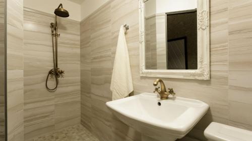 a white bathroom with a sink and a mirror at Castle Spa Wagenküll in Taagepera