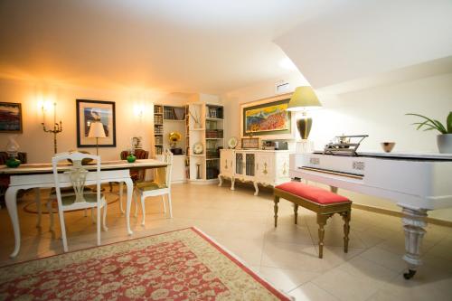 ファロにあるOpus One Luxury Guest House & Wineのリビングルーム(テーブル、ホワイトピアノ付)