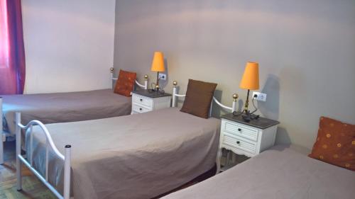 a room with two beds and two lamps on tables at Casa Dom Manoel in Portalegre