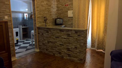 a room with a brick wall and a tv on a wall at Casa Dom Manoel in Portalegre