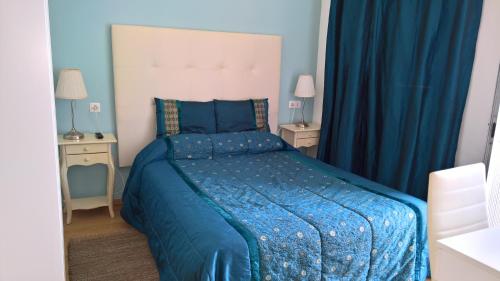 a bedroom with a blue bed and blue curtains at Casa Dom Manoel in Portalegre